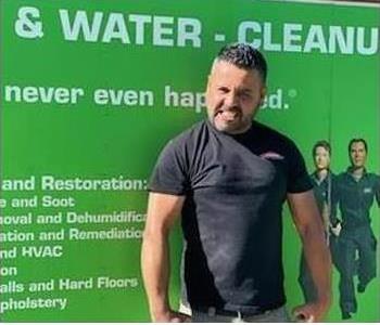 Juan standing in front of a green van. 